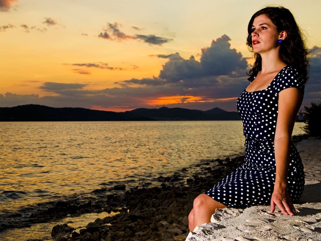 RetroCat im Kleid mit Polka-Dot-Muster vor dem Sonnenuntergang