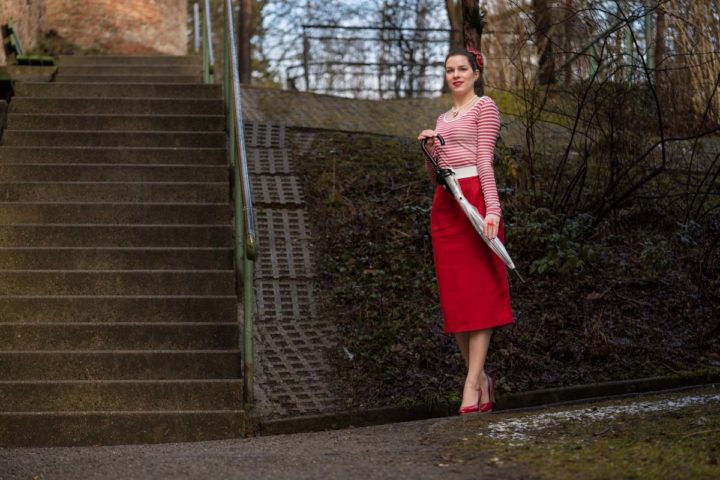 Für nasskaltes Wetter: Ein Regenschirm und roter Rock im Retro-Stil