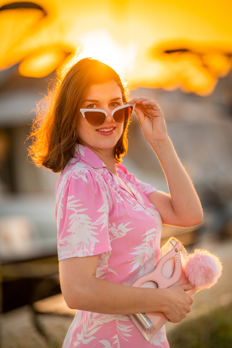 RetroCat mit pinker Retro-Handtasche und weißer Retro-Sonnenbrille im Urlaub