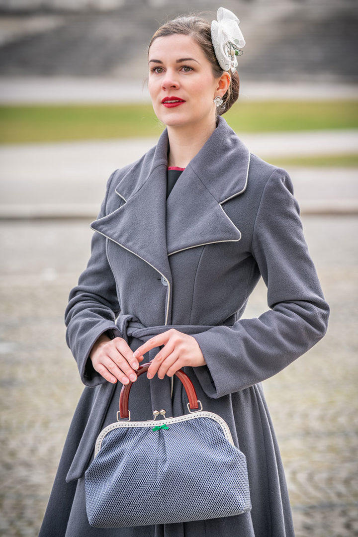 RetroCat mit einem weißen Fascinator und einer passenden Retro-Handtasche von Nadja Christner