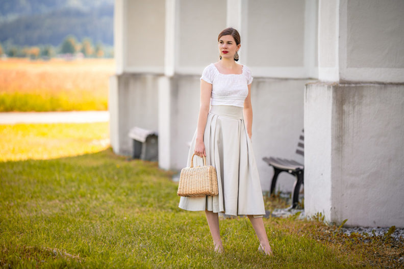 RetroCat mit einem romantischen Retro-Outfit vor einer Kirchenmauer