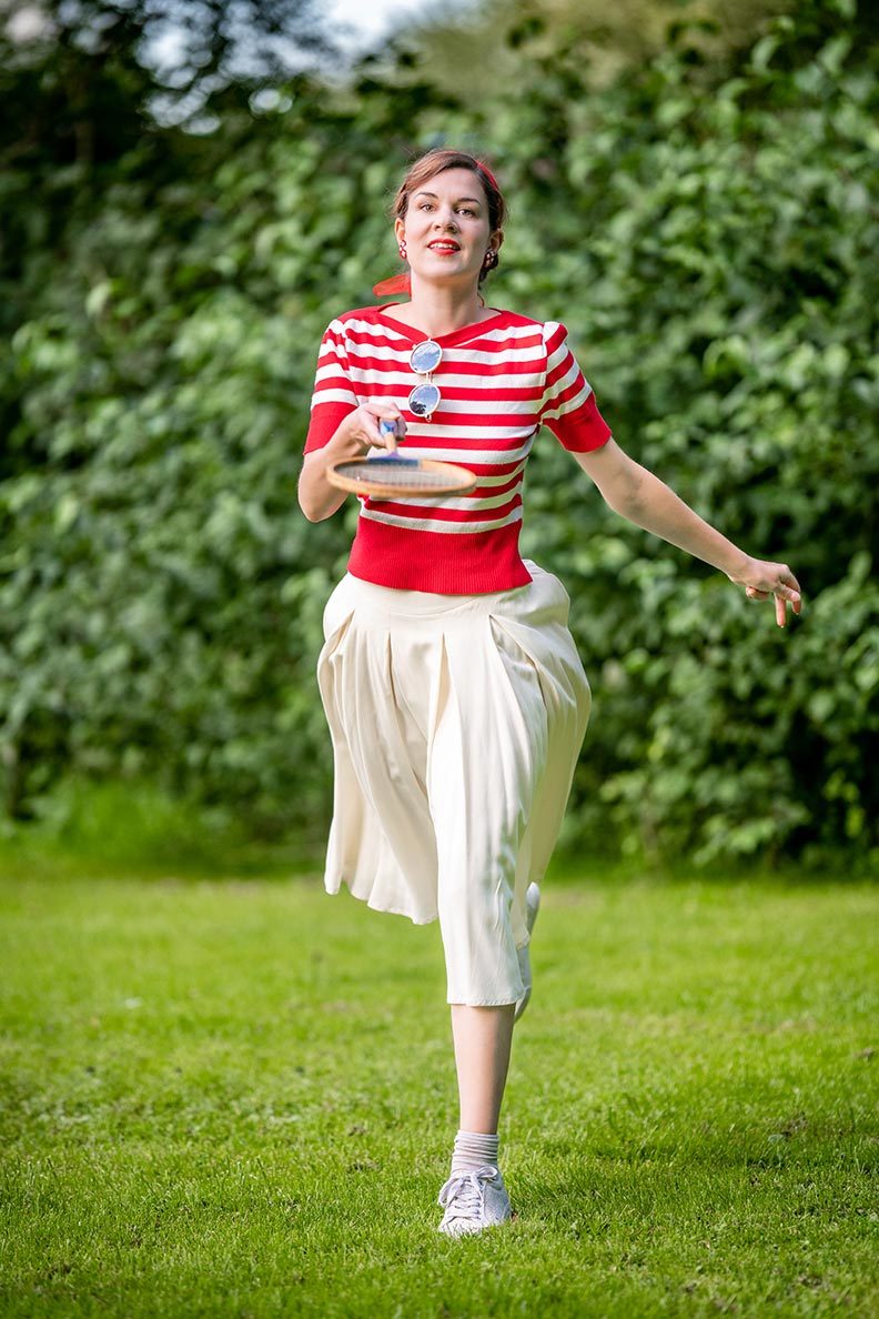 RetroCat wearing 1930s sportswear during a badminton match at the park