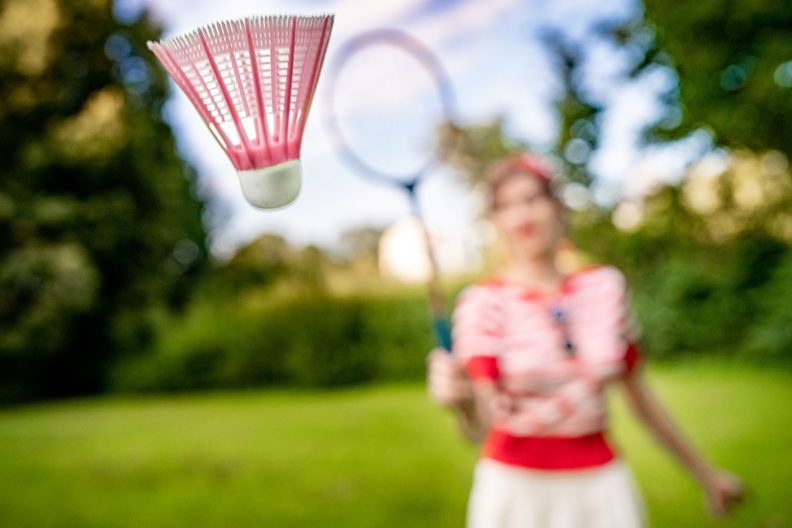 RetroCat beim Badminton-Spielen in einem 30er-Jahre-Sportoutfit