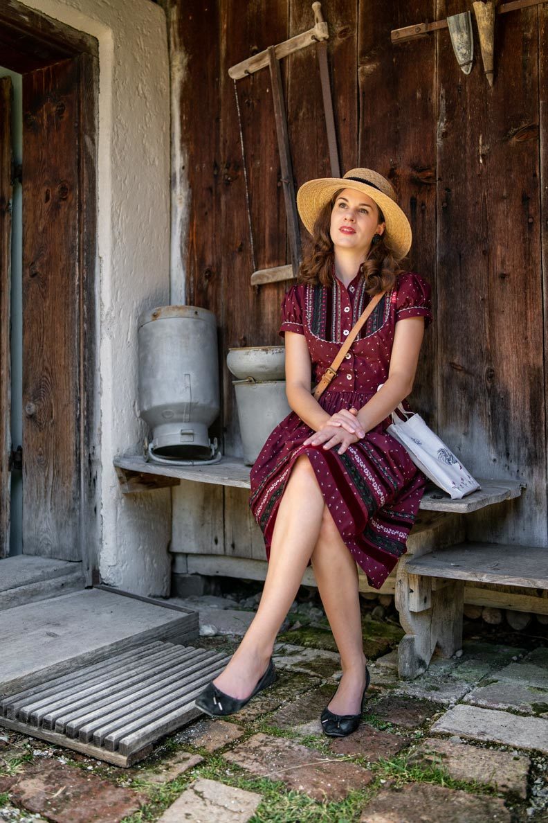 RetroCat with a traditional Bavarian dress by Lena Hoschek and a straw hat in the countryside
