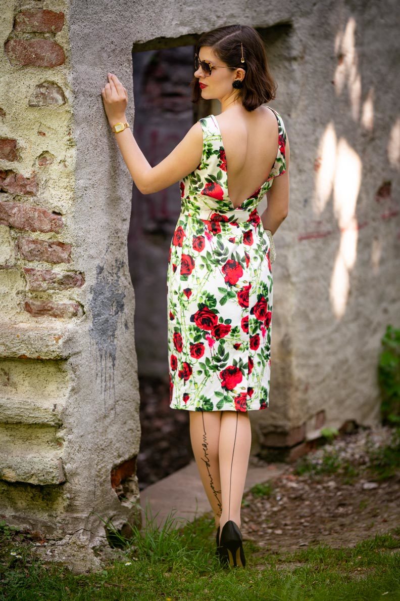 RetroCat in einem Kleid mit Rosenmuster und tiefem Rückenausschnitt