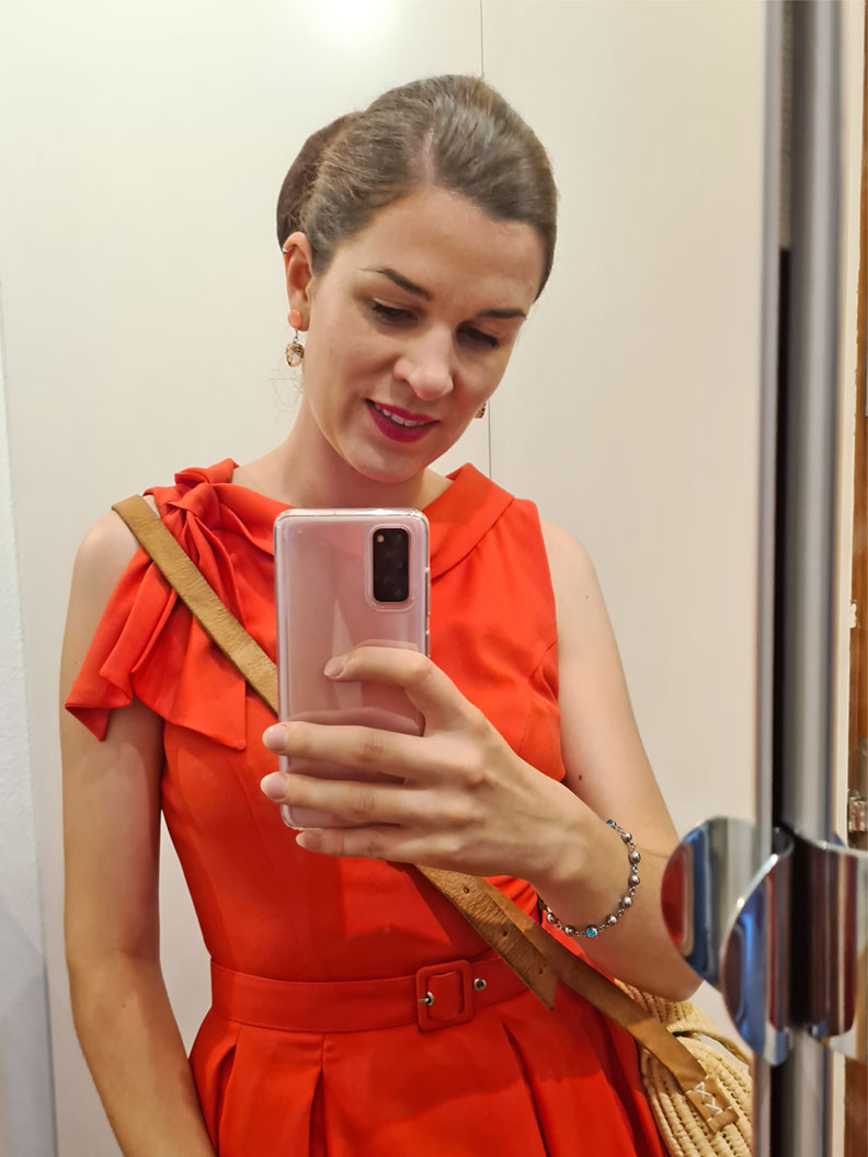 RetroCat wearing a coral summer dress in front of a mirror