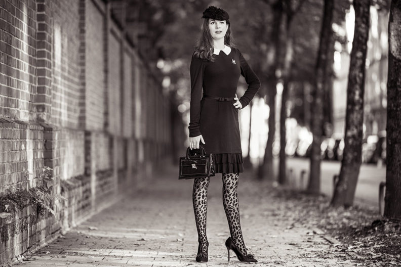 An elegant all black outfit: RetroCat wearing leopard tights and a little black dress