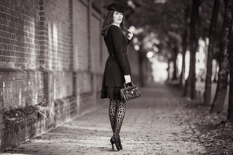 An elegant all black outfit: RetroCat wearing a dress by Jools Couture