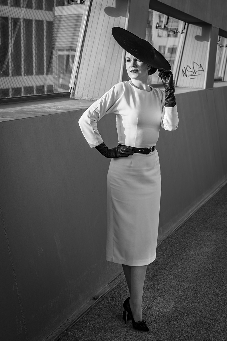 RetroCat wearing a white pencil dress and black retro accessories