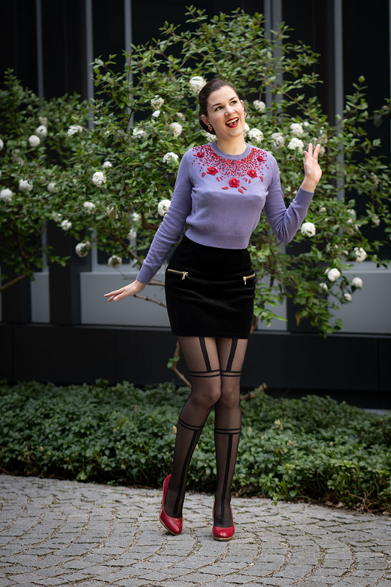 60s-Look: RetroCat mit lila Pullover, Minirock und Strumpfhose