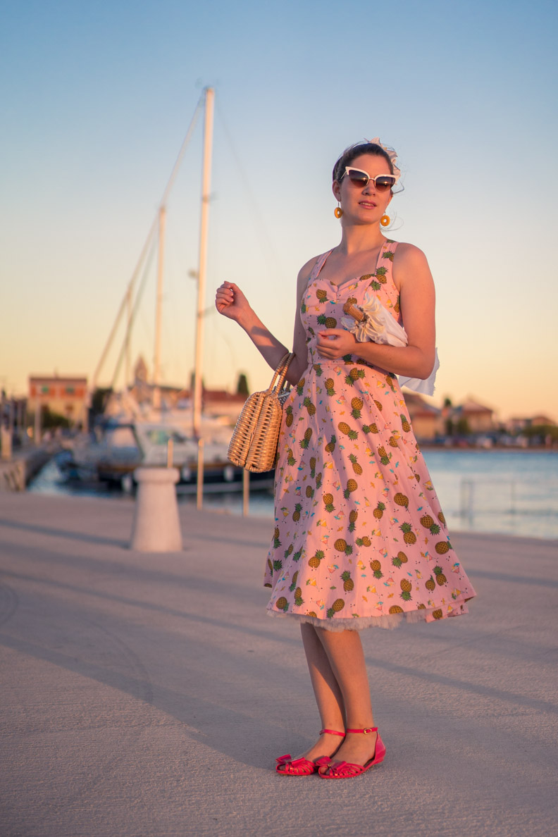 RetroCat trägt ein rosa Sommerkleid mit Ananas-Muster im Urlaub