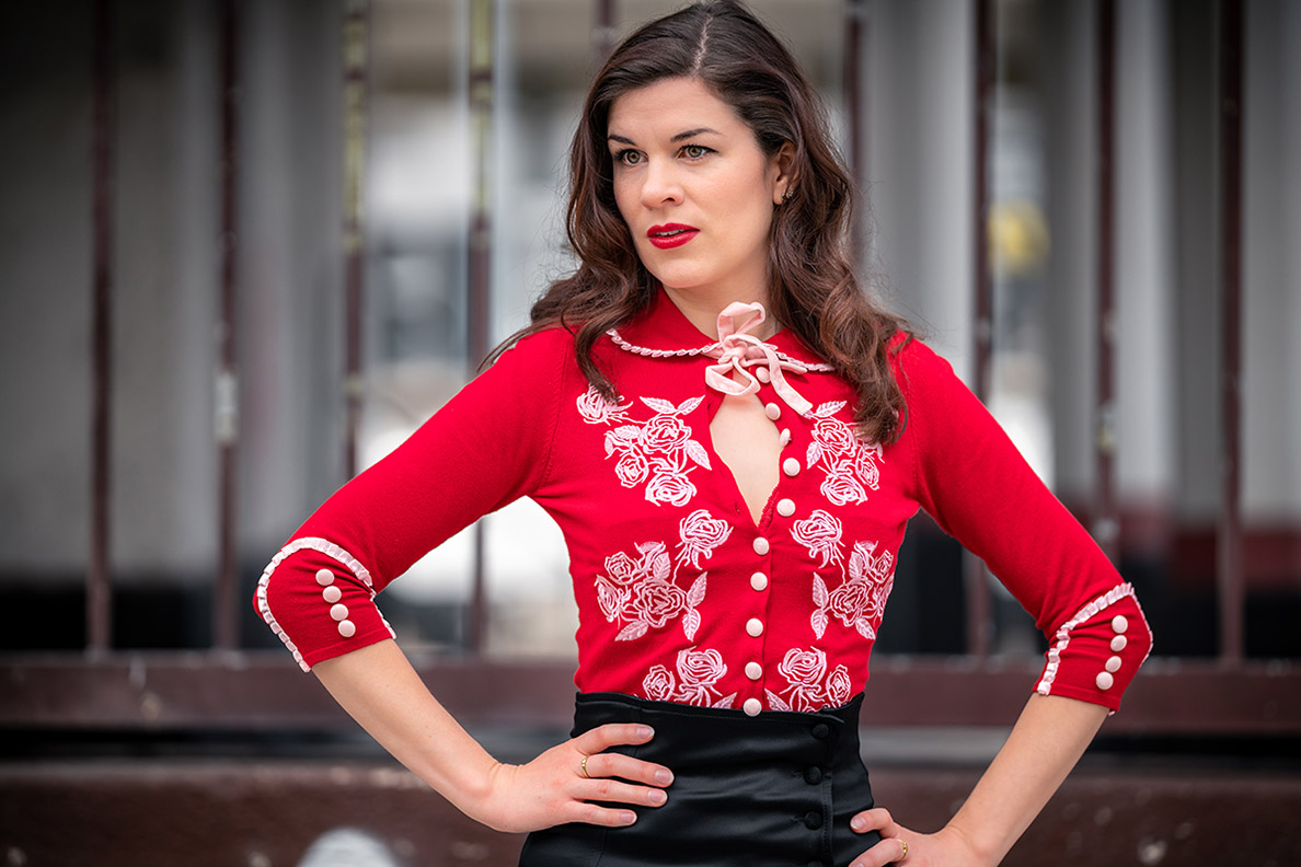 RetroCat wearing a red cardigan with flower decoartions by Dita von Teese