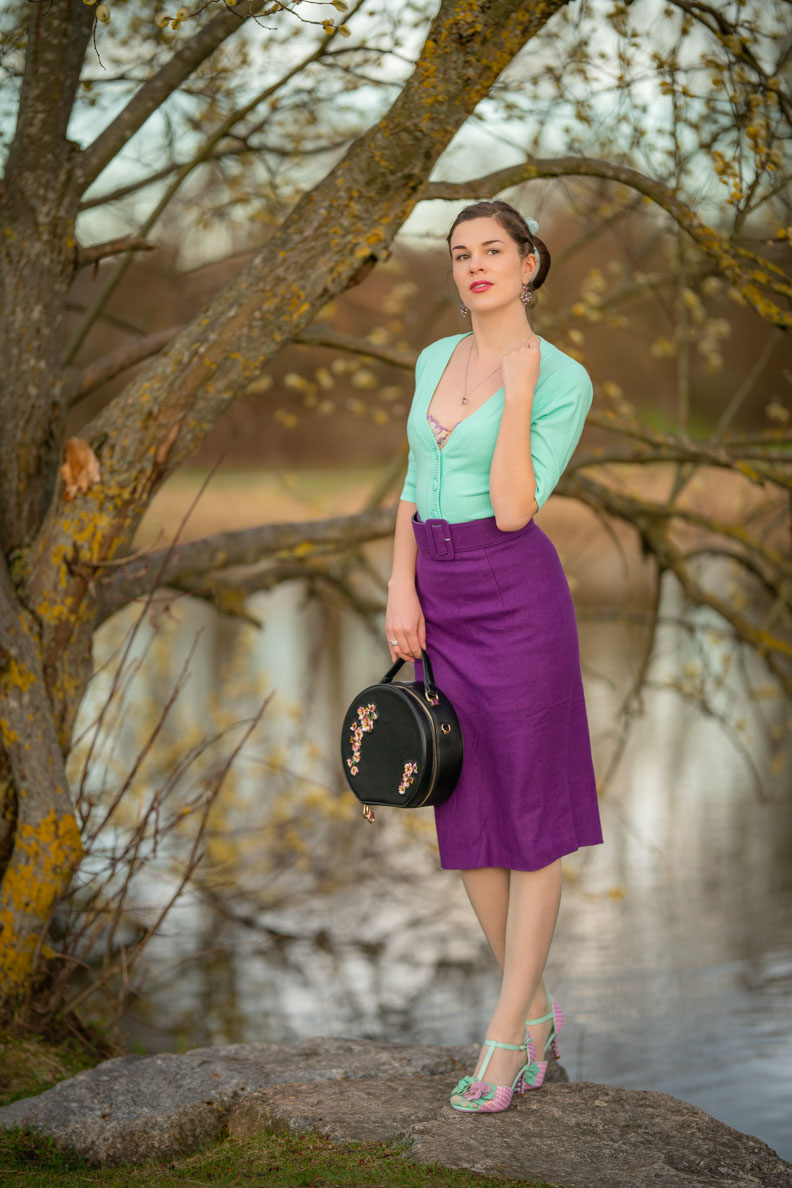 RetroCat wearing a lilac pencil skirt and a colourful cardigan