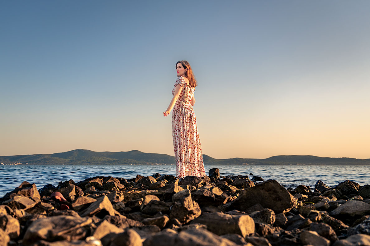 RetroCat in einem langen Sommerkleid am Strand an der Küste Kroatiens