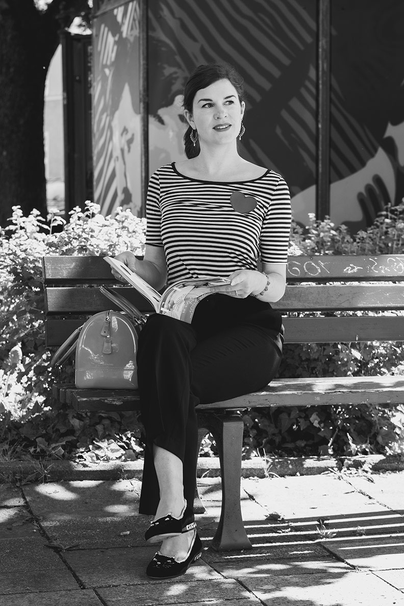 French Chic: RetroCat mit Streifenshirt und schwarzer Hose beim Lesen