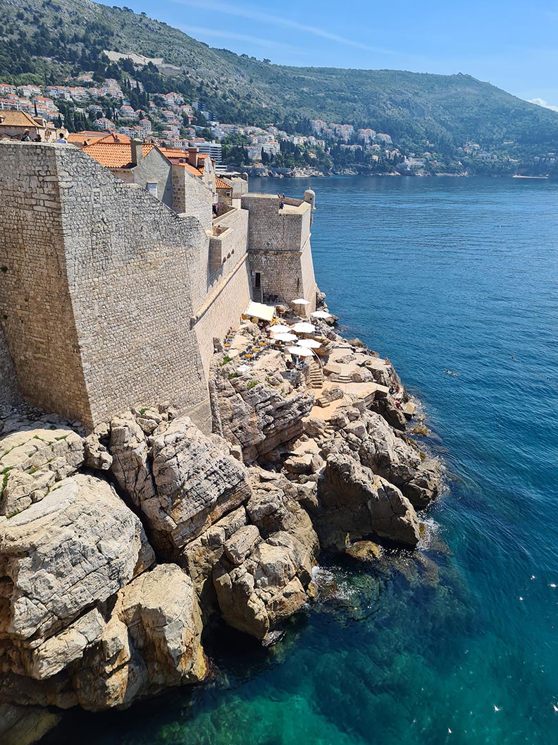 Blick auf die Buza Bar auf den Felsen vor der Stadtmauer Dubrovniks