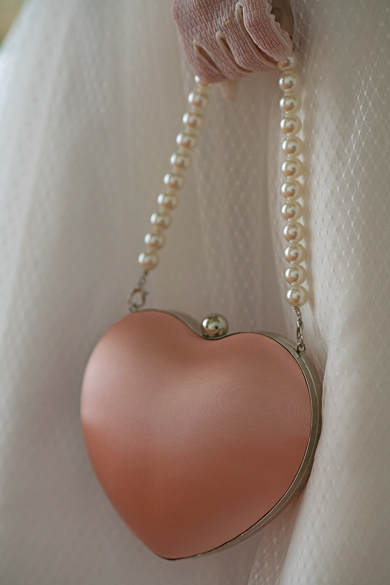 A pink handbag with pearls