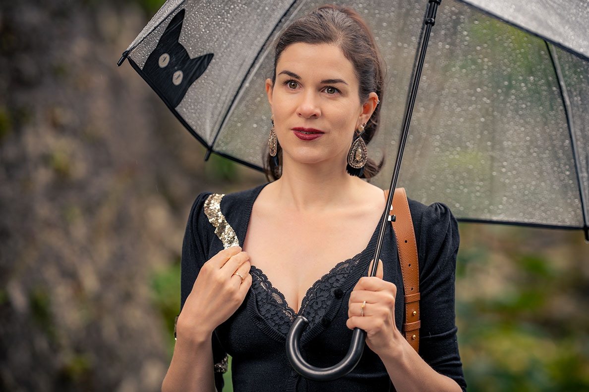 Glamorous autumn outfit: RetroCat wearing an umbrella and huge earrings