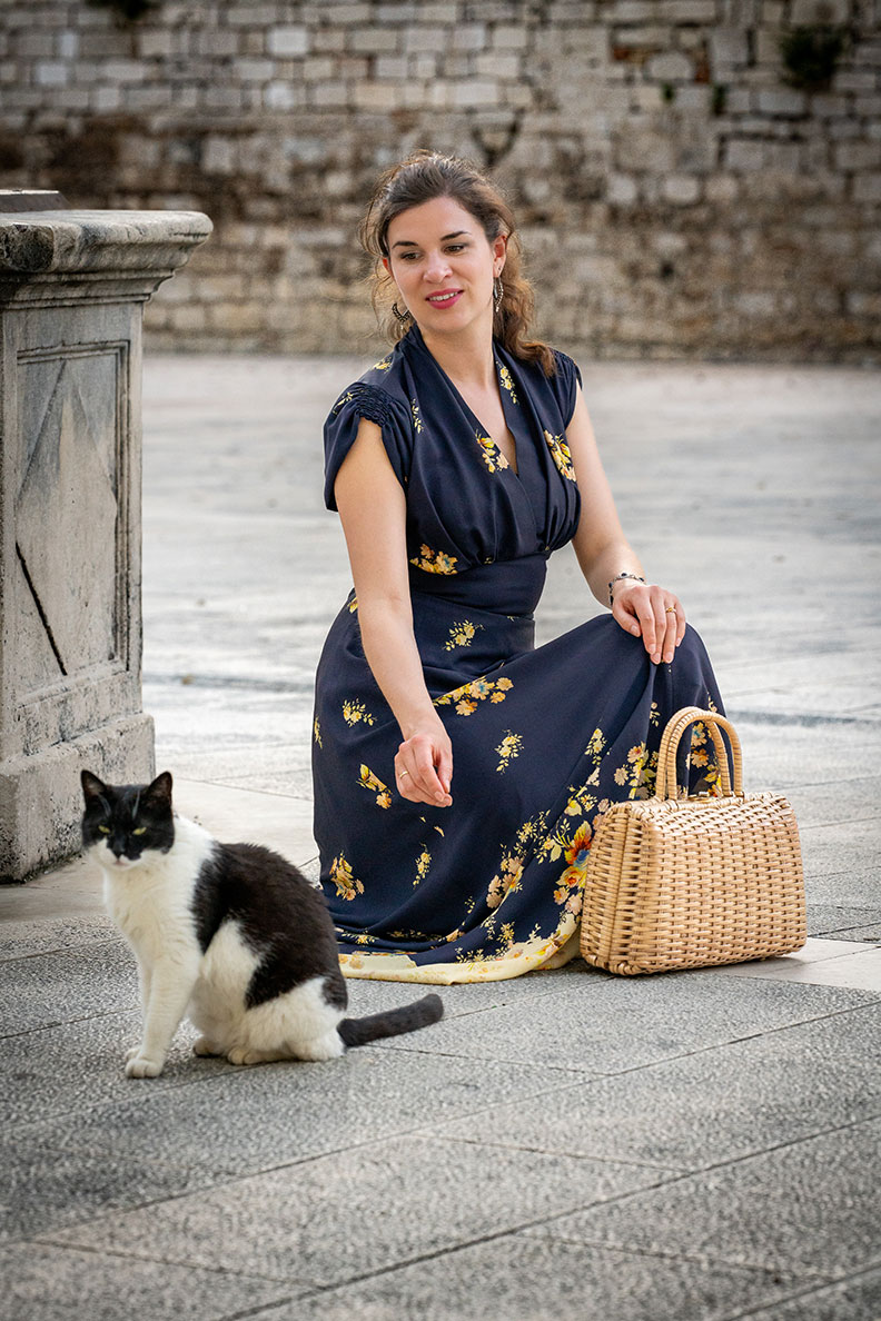 RetroCat in einem dunkelblauen Maxikleid im 30er-Jahre-Look