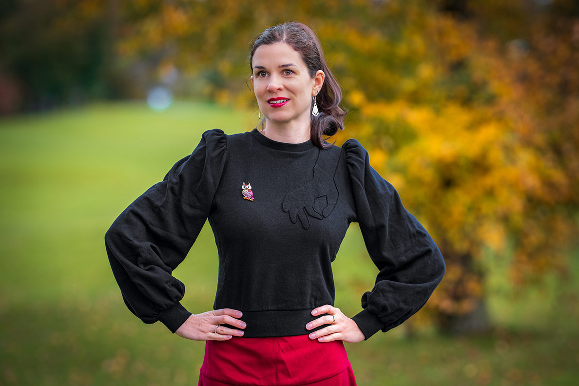 RetroCat in einem warmen Lena Hoschek Sweater mit Puffärmeln und einer Brosche