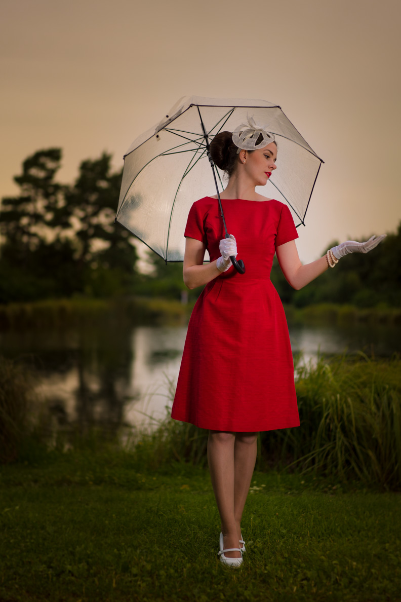 RetroCat in einem roten 50er-Jahre-Vintage-Kleid im Sommerregen