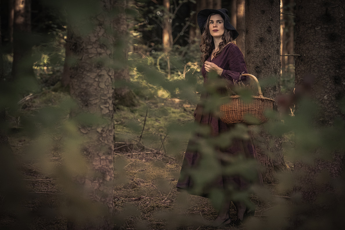 RetroCat in the style of a hedge witch on the move in the forest