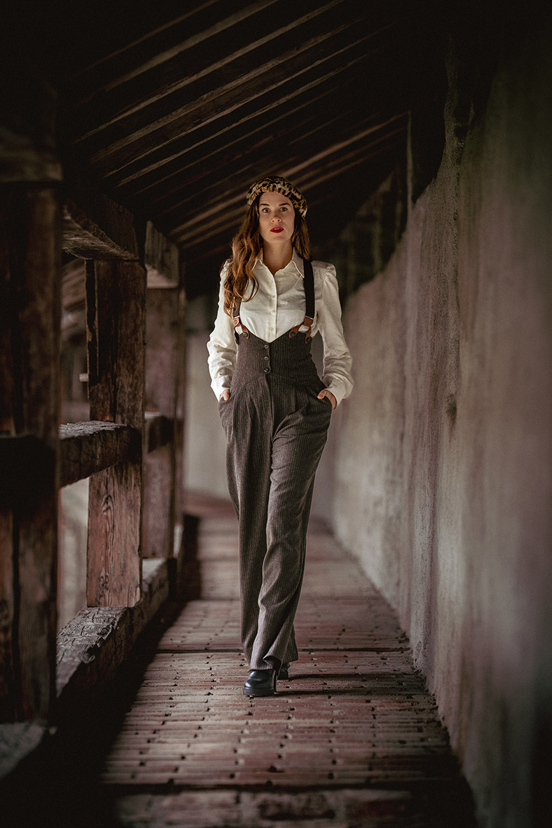 RetroCat with high-waisted trousers, suspenders and a vintage-style blouse