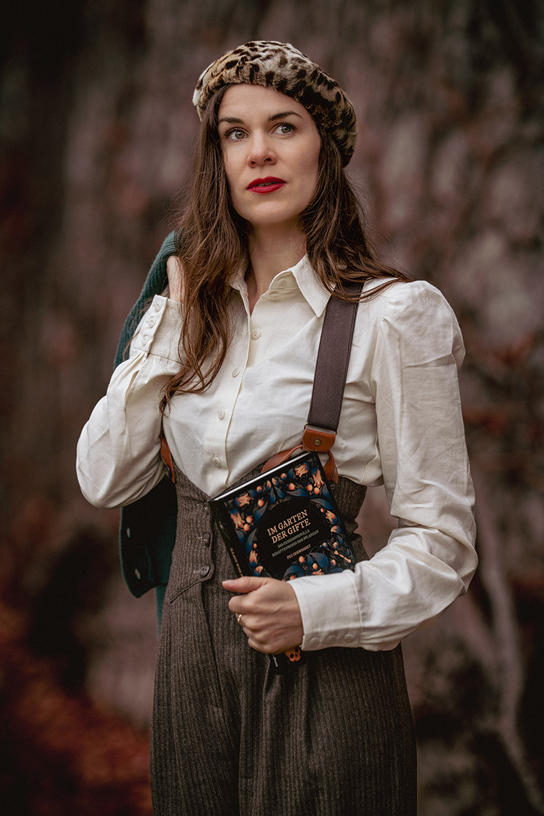 RetroCat with suspenders, blouse and vintage cap in a 1940s look