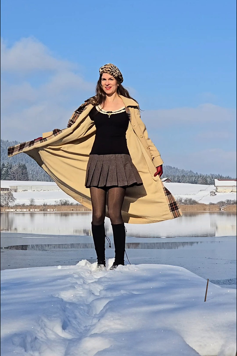 RetroCat mit warmen Strumpfhosen, Rock und Mantel im Schnee