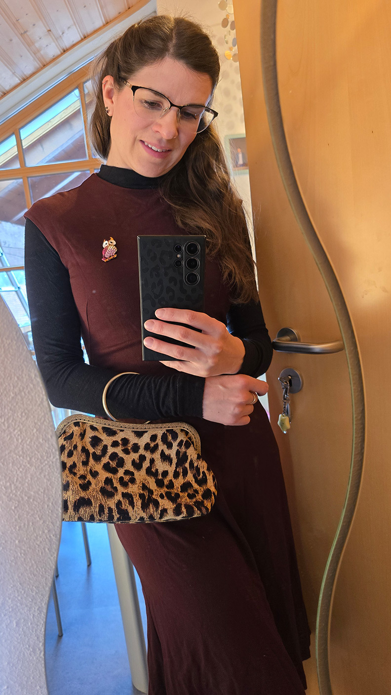 RetroCat wearing a dark red dress and leopard handbag