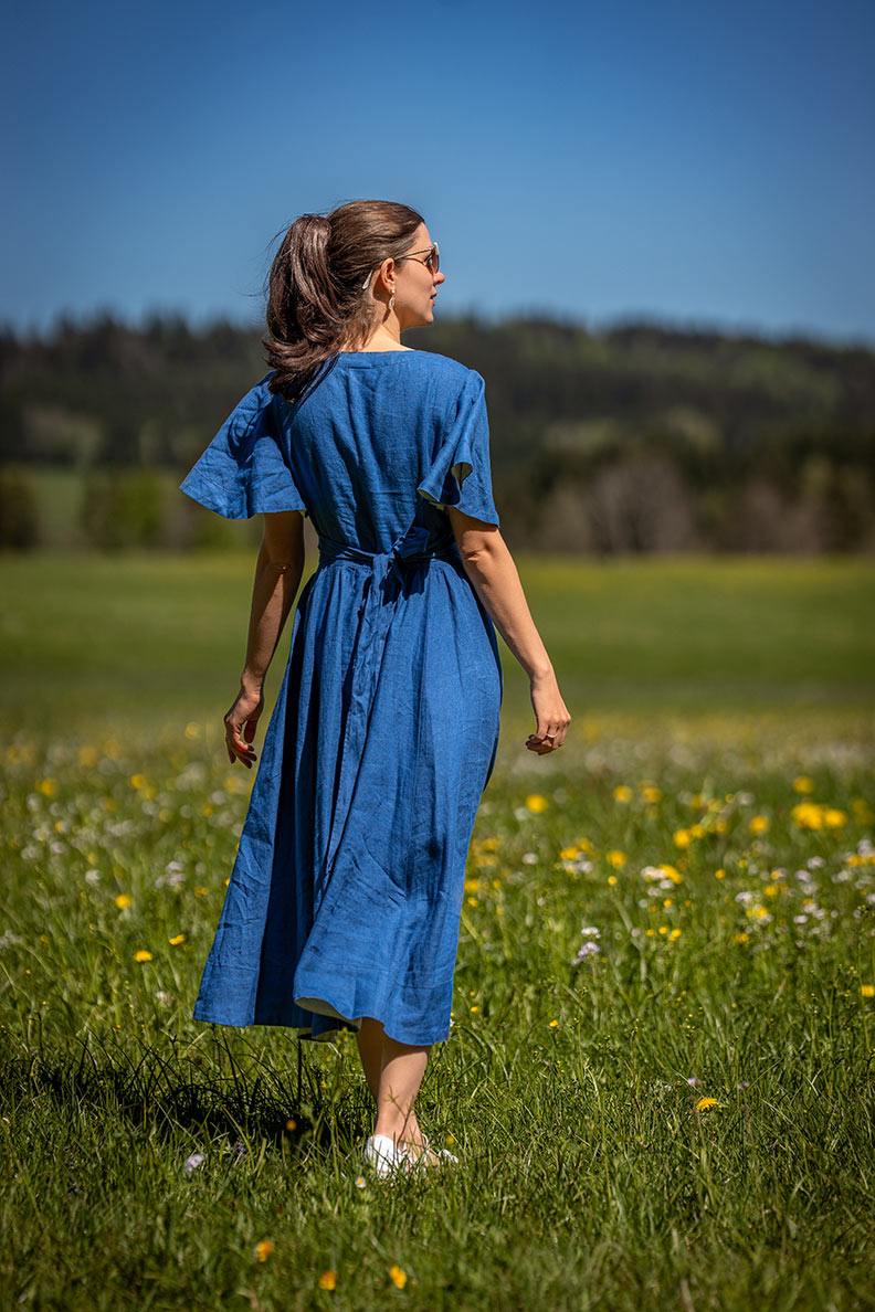 RetroCat in einem hellblauen Leinenkleid in einer Blumenwiese