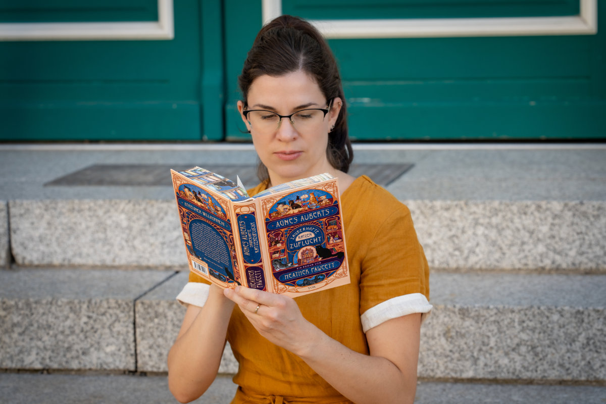RetroCat beim Lesen vom Cozy Fantasy Buch Agnes Auberts zauberhafte Katzenzuflucht