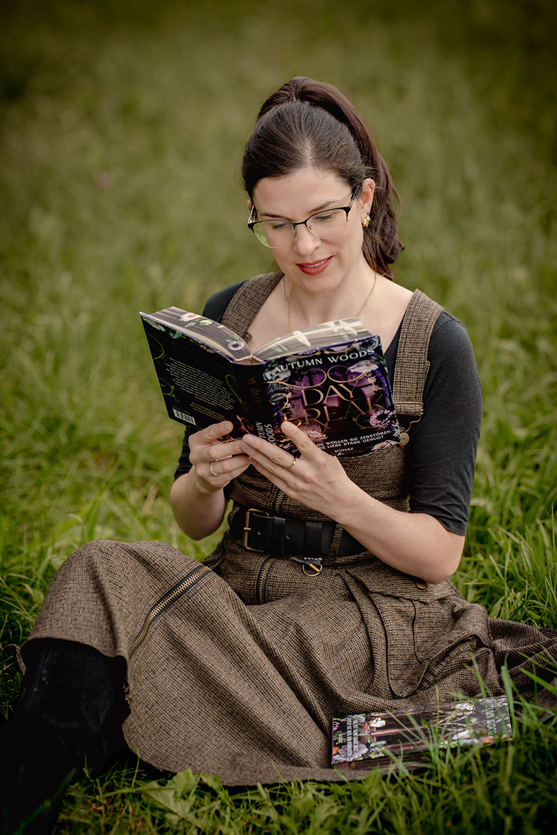 RetroCat beim Lesen von Daybreak von Autumn Woods - Dark Academia Buch